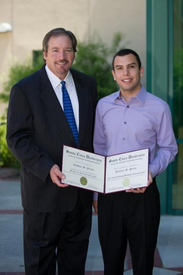 Two men posing; one holds a certificate labeled Anthony Prieto OSE 2012.