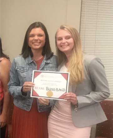 Two women smiling and holding a 2nd Place Winner certificate.