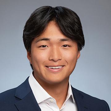 Man in black suit jacket white shirt smilling