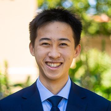 Man in suit and tie outdoors smiling