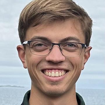 Man with glasses smiling outdoors