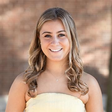 Woman in yellow dress outdoors smiling