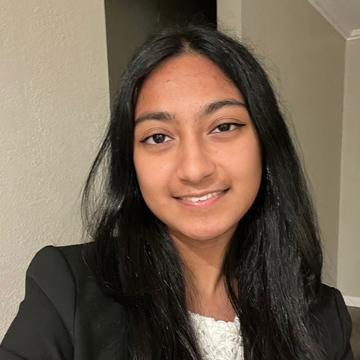 Woman smiling in black blazer with white shirt