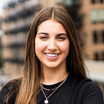 Woman smiling in black shirt outdoors