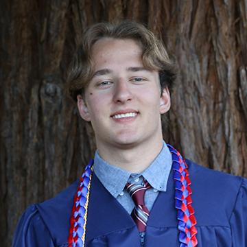 Man in graduation gown smiling