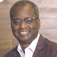 A person in a purple blazer smiling. Image titled Derrick Roman.