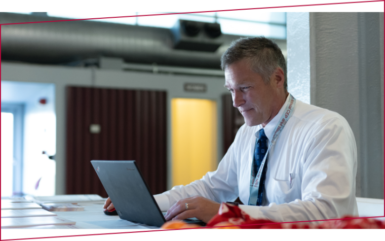 Man in a white shirt working on a laptop at Leavey Executive Centers Annual Symposium