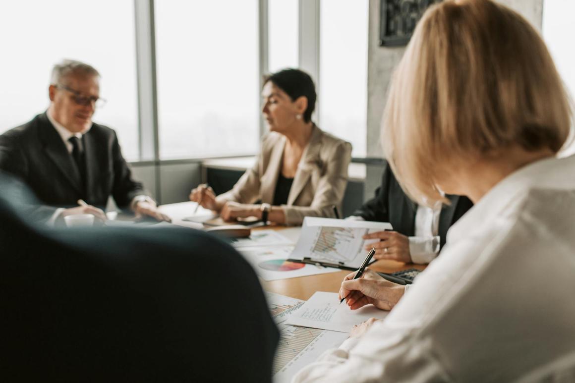 C-suite meeting with members analyzing graphs