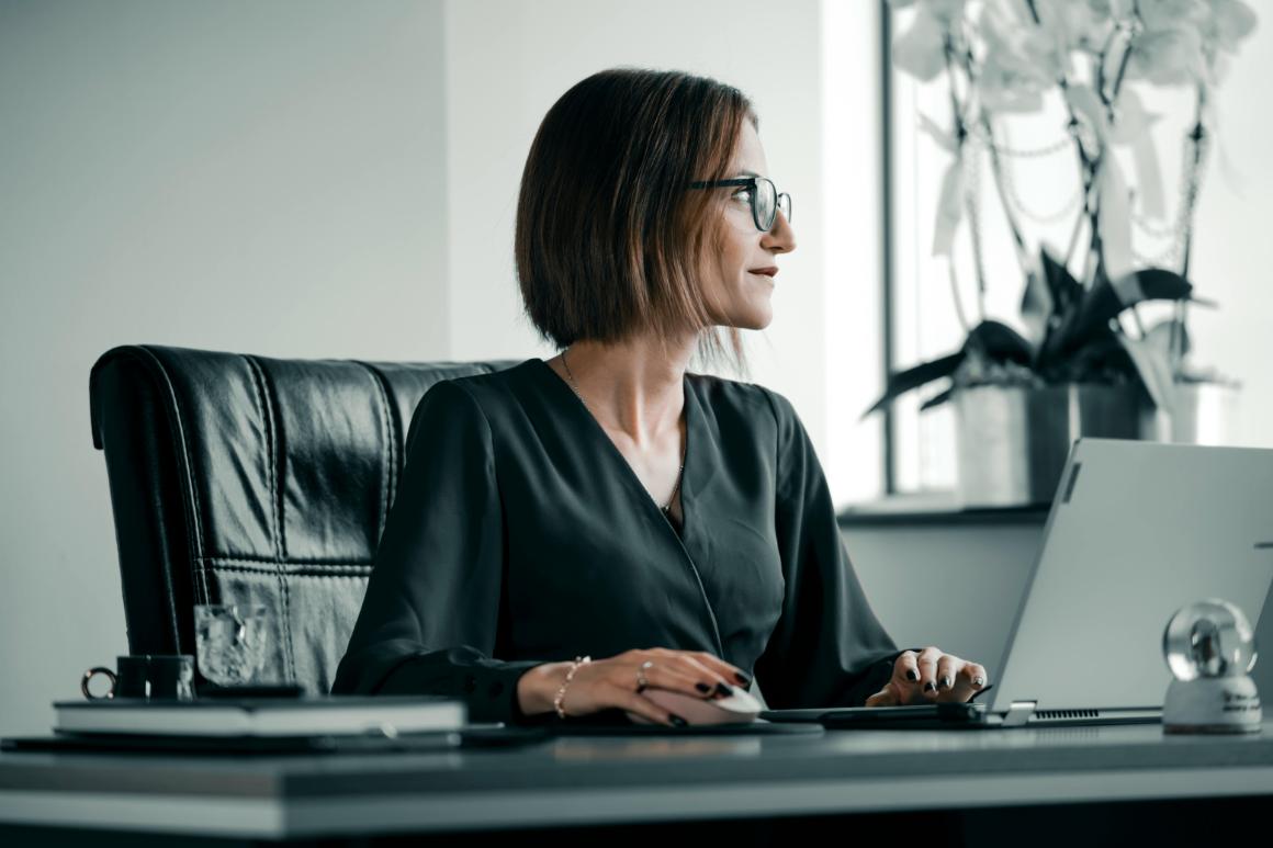 Business professional working on laptop staring into the distance