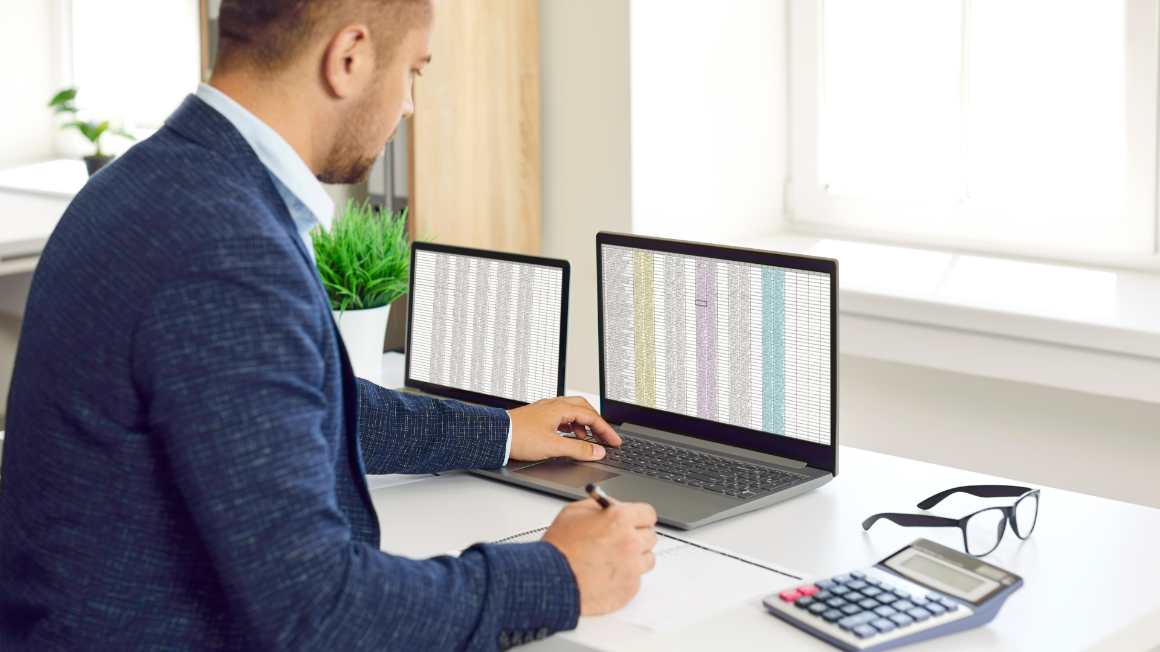 Business profesional comparing spreadsheets on laptop to paper