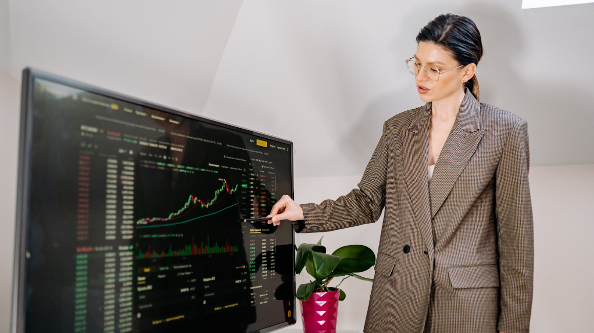 Woman in blazer presenting findings from stock and finance results