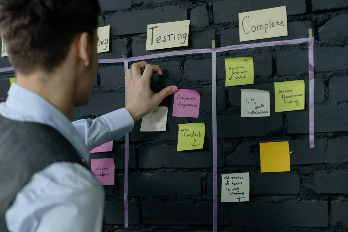 Product manager moving tasks on sticky notes between stages