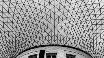 Geometric ceiling design with a curved glass and metal structure.