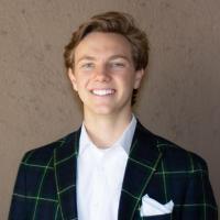 A person wearing a suit jacket with a white shirt and pocket square.