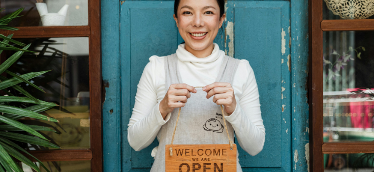 Photo of woman holding open sign
