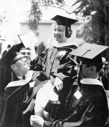 Four graduates in caps and gowns holding diplomas, smiling, titled Mary Somers Edmunds Historic Picture.