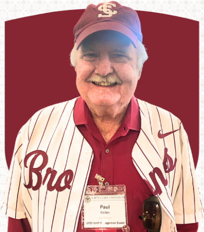 A smiling man in a Santa Clara University baseball cap and athletic shirt. His nametag reads Paul Neilan, Alumni Relations.