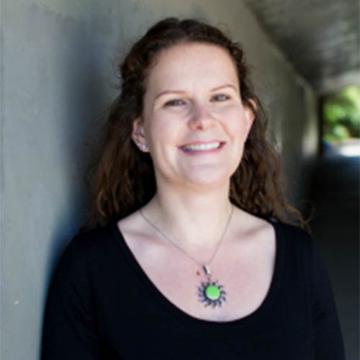 A smiling woman with a green pendant, titled Olga Rocklin Psychotherapy.