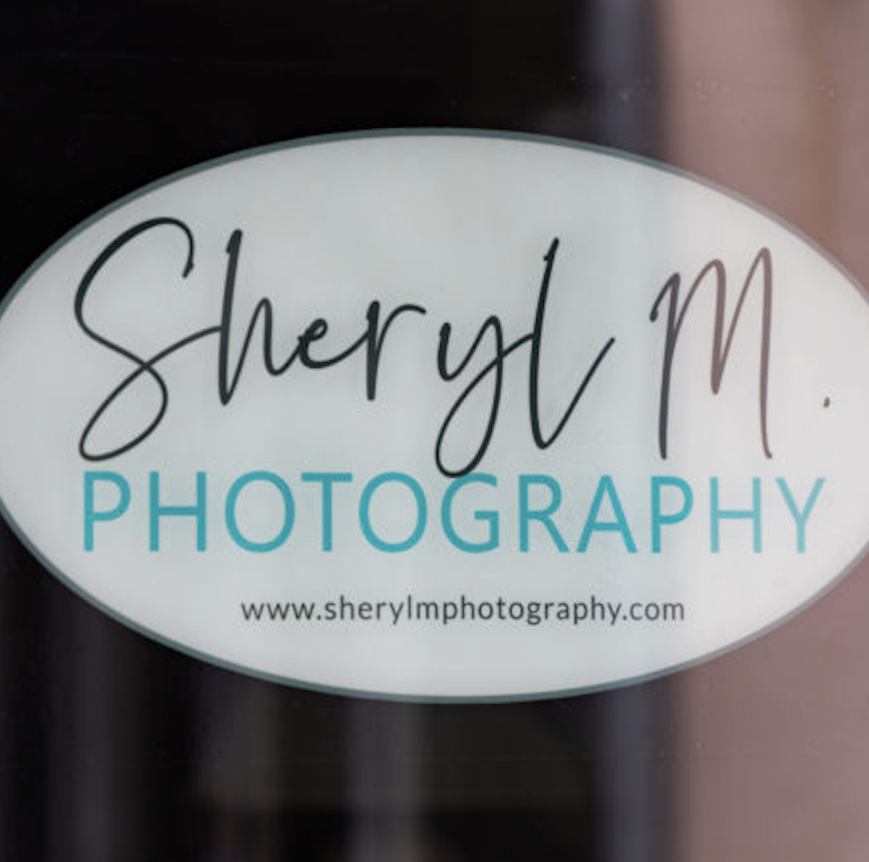 Sheryl M Photography logo with tagline a visual expressionist in a white oval.