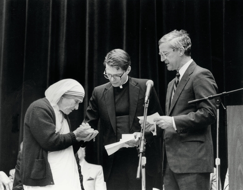 Mother Teresa receives an award from two men at SCU event.