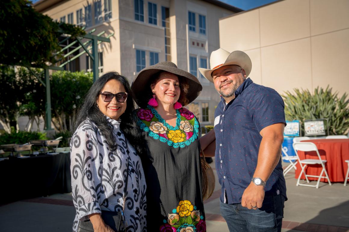 Two women and one man of Latinx ancestry smiling for the camera at Santa Clara Universitys Latinx Alumni Social at Grand Reunion.