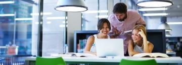 Two people collaborating with a laptop in a modern office.