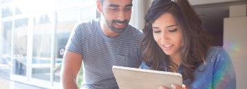 A couple looking at a tablet together.