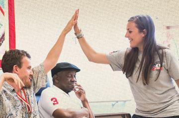 Three people high-fiving in a casual, cheerful setting.