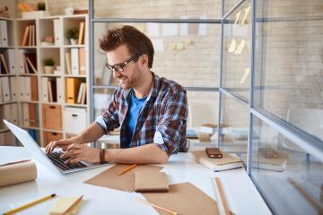 A person working on a laptop at a desk.