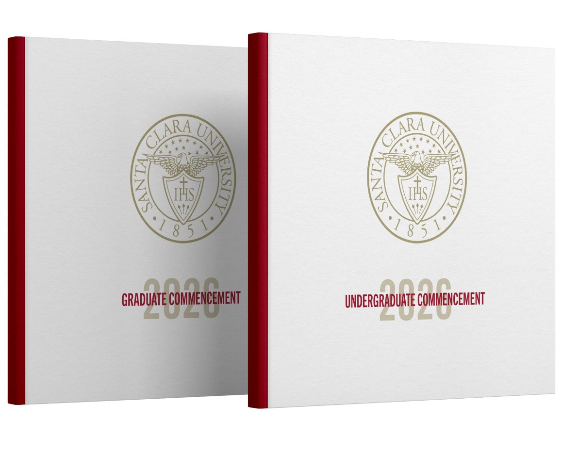 Two program books standing side by side with covers that says 2026 Undergrad and Grad Commencement.