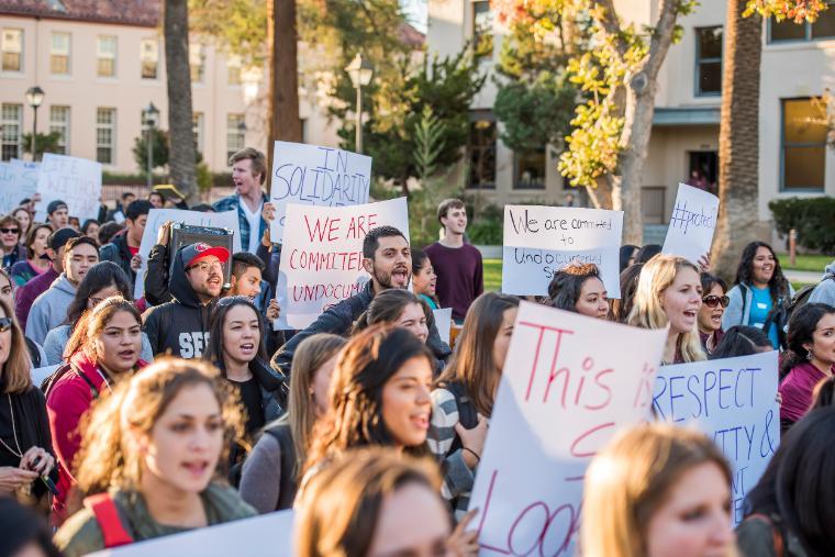 Students holding signs and protesting outdoors during a walkout.