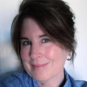 A person smiling in a blue shirt.