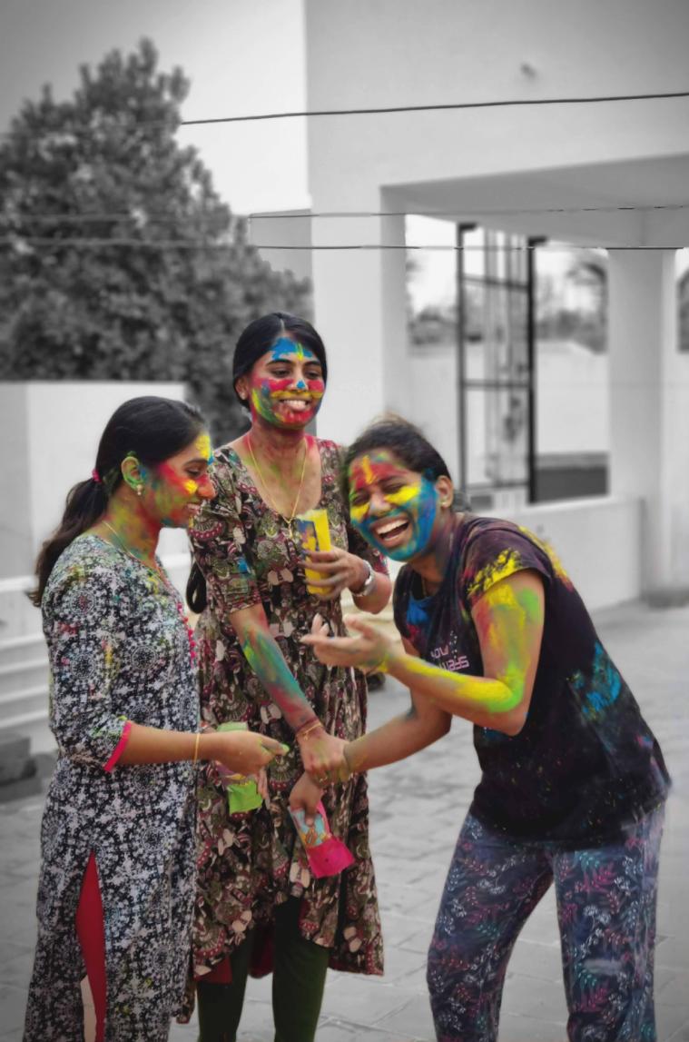 Decorative; three students covered in Holi colors 