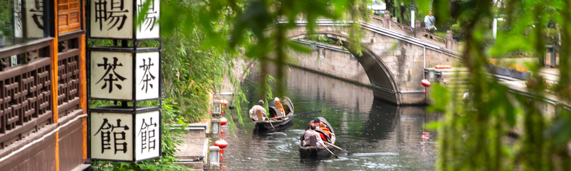 Zhejiang, Shaoxing, China; Tea house on the water with boats floating by