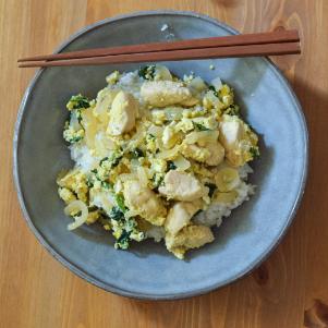 A bowl of Oyako Donburi with chopsticks on the side.