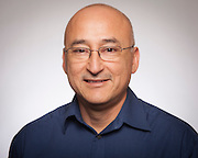 A man smiling against a plain background.