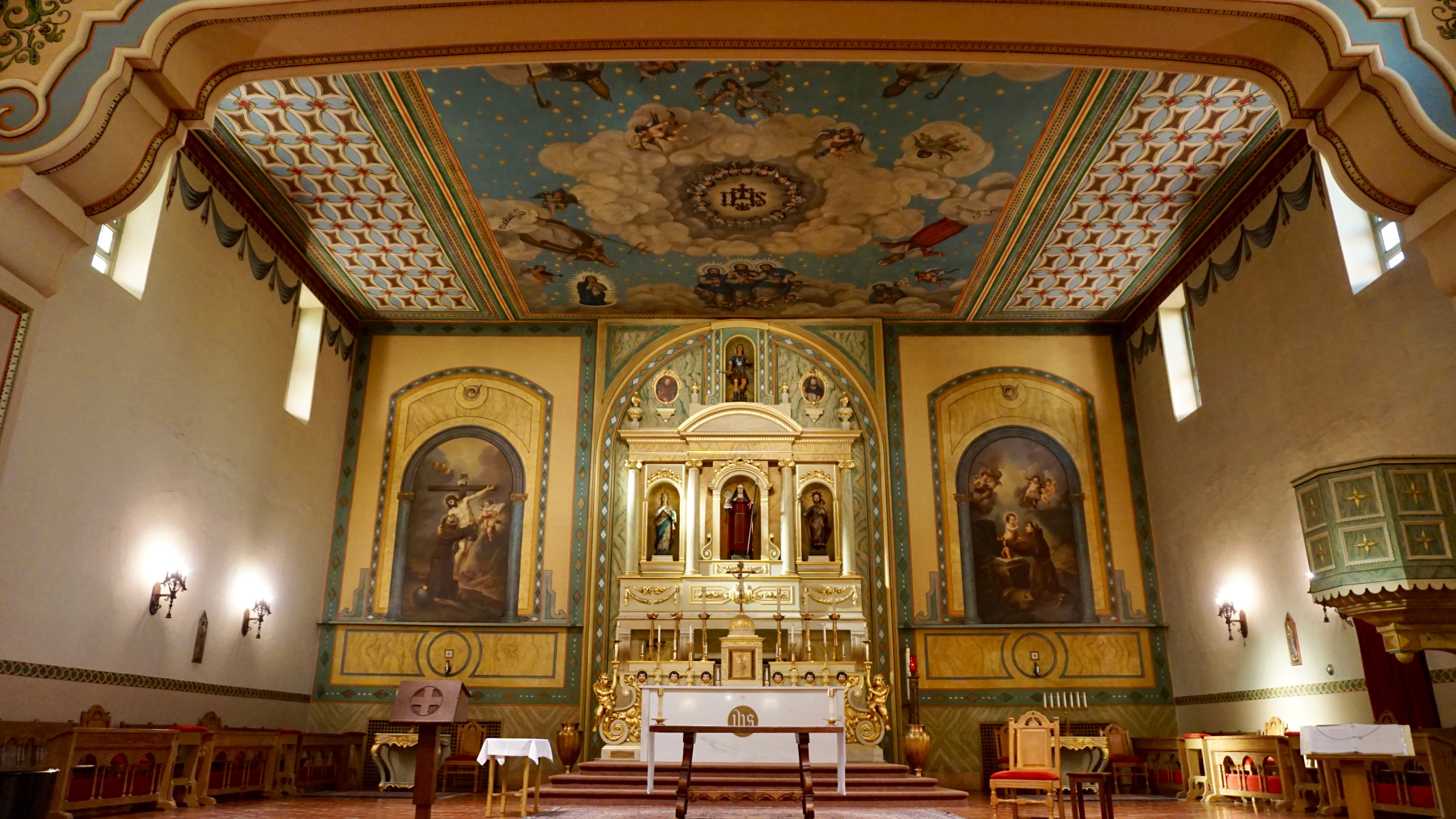 Ornate church sanctuary with paintings and a decorated ceiling titled Mission Sanctuary.