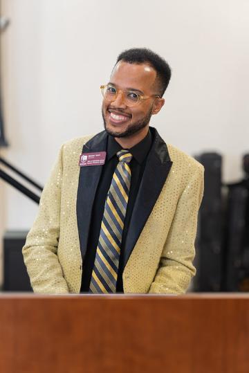 Bernell smiling in a gold blazer
