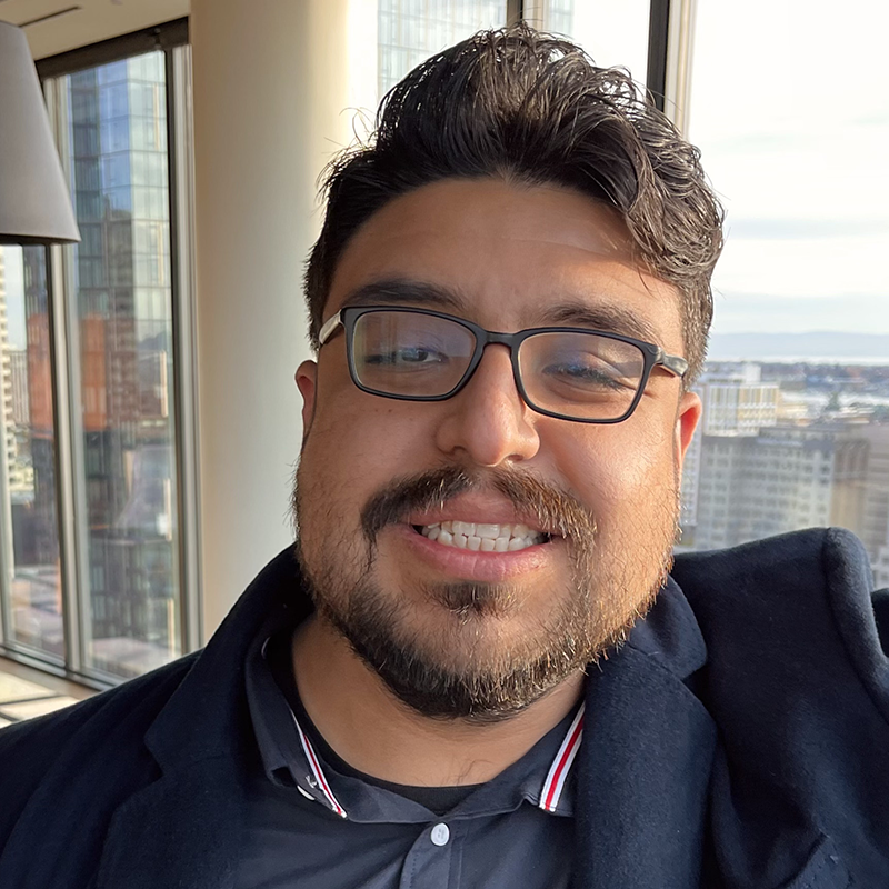 man in glasses smiles at camera 