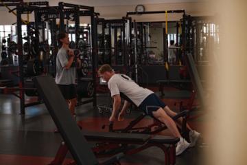 Students lifting weights in the weight room
