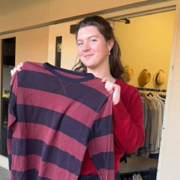 A student holds up a plaid shirt in from of Buckys Closet