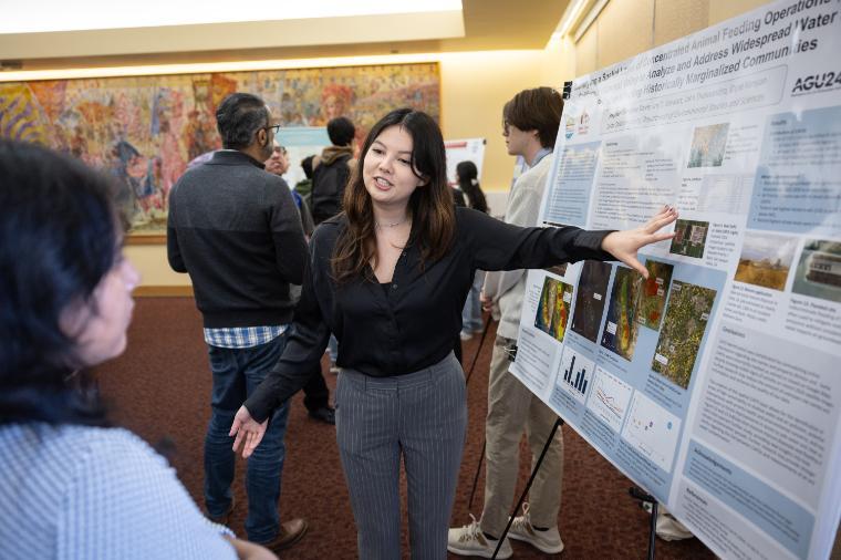 A student researcher speaking at a poster session