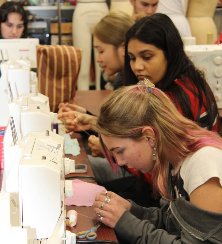 Students working with sewing machines at a Maker Night.