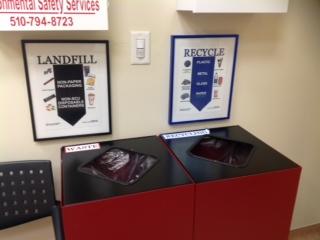 Office waste bins labeled for landfill and recyclable items.