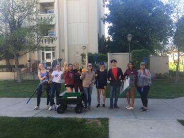 Group of students with wagon and fruit pickers in front of Swig Hall