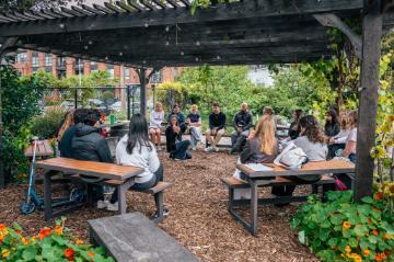 A class being taught under the pergola in the Forge Garden