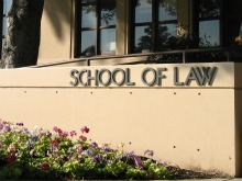 School of Law sign on a building with plants in front. image link to story