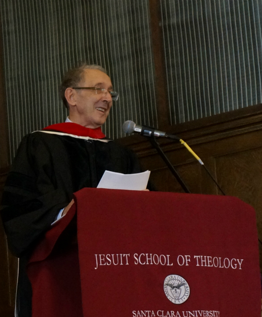A person speaking at a podium labeled Jesuit School of Theology. image link to story