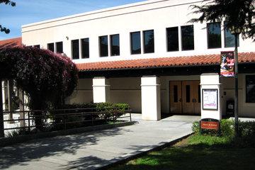 Two-story building labeled Music and Dance Facility 2.0 with adjacent trees.