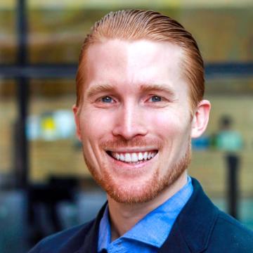 A person smiling in business attire.